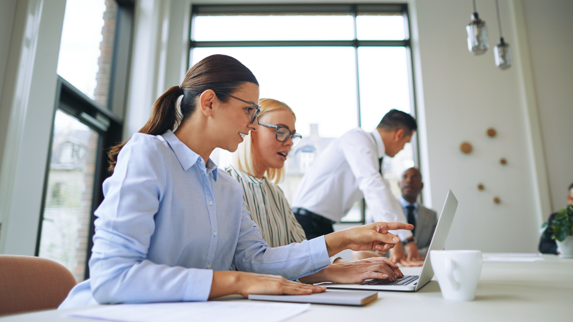 Smiling businesswomen working with a laptop in on office boardroom